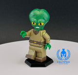 Green alien figure with a brown outfit on a white platform, branded with Calypso Customs.